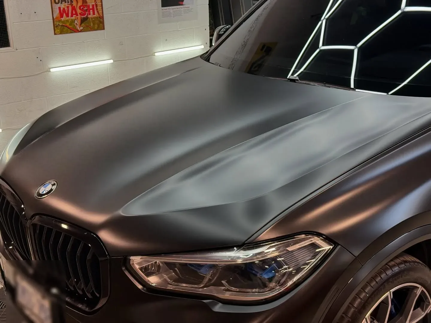 Close-up of the matte black PPF on a BMW X5 hood
